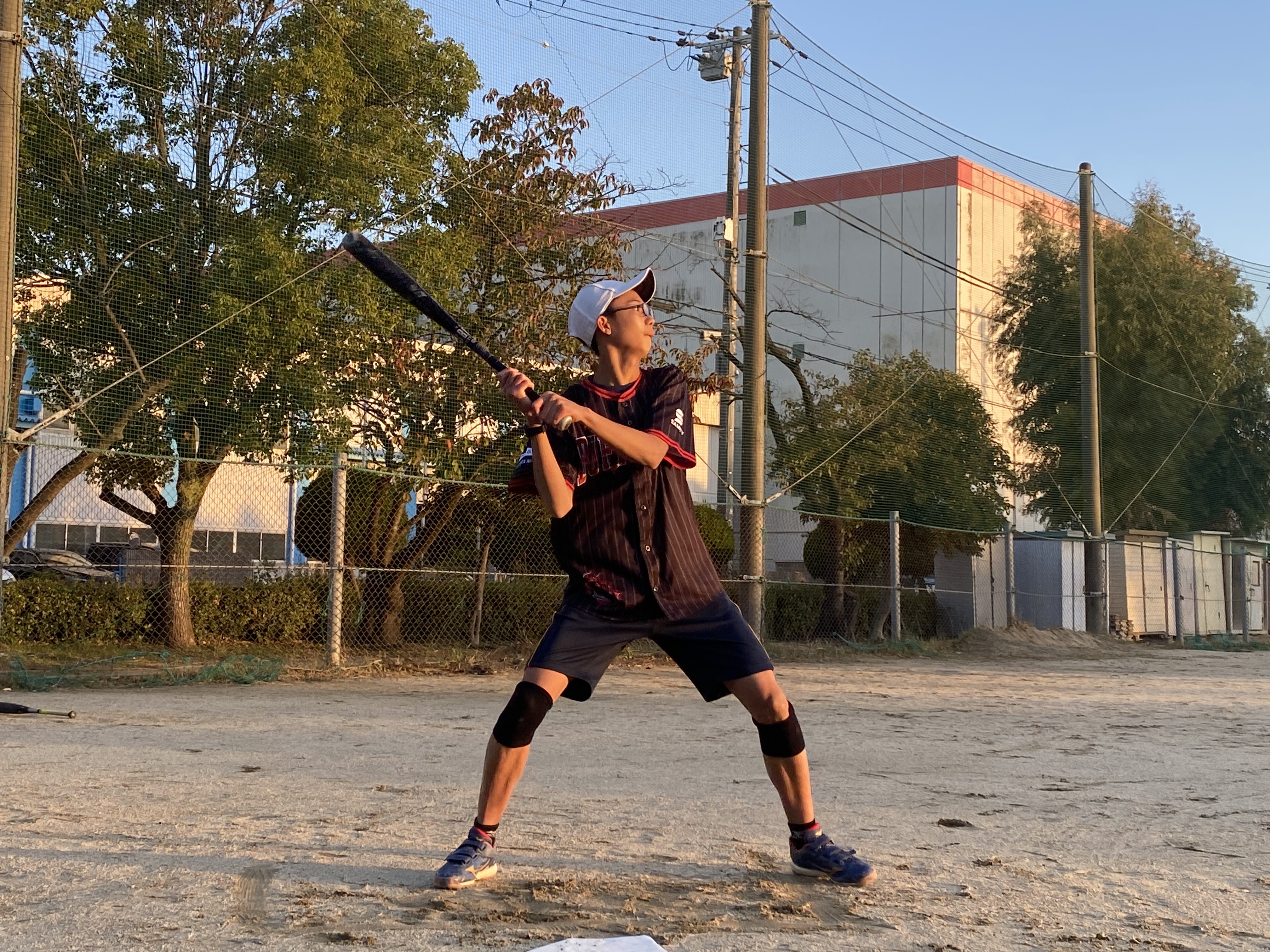 子どもが野球のバッドを構えている