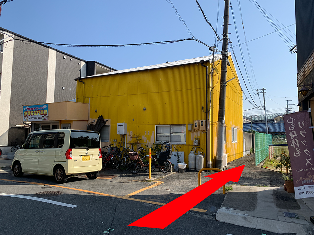 黄色の建物の横を通る